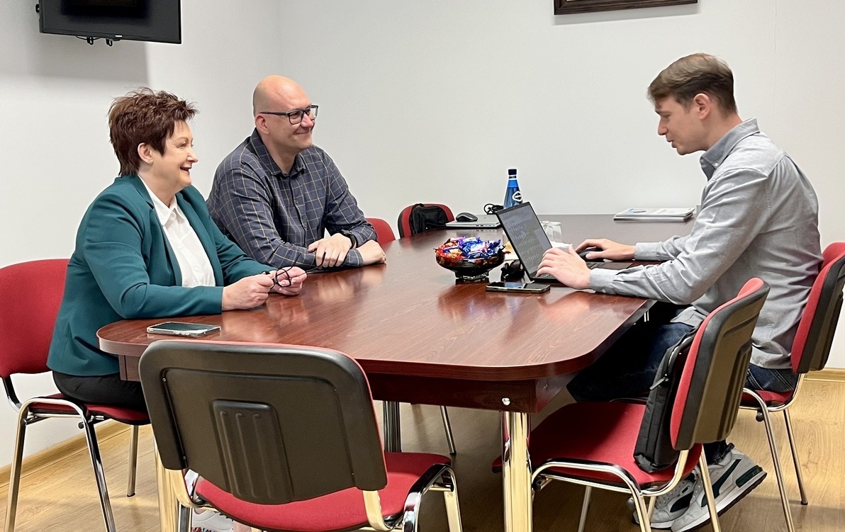 Spotkanie w biurze ZKM, przy stole siedzą i rozmiawiają trzy osoby