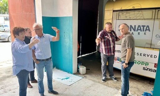 Zdjęcie wykonano w garażu na bazie ZKM podczas wizyty wykonawcy inwestycji. Na fotografii pieć osób. Rozmawiają w miejscu gdzie stanie stacja ładowania dla autobusów elektrycznych